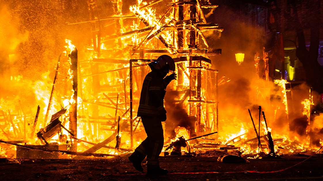 Fire Fighter In Front Of Electrical Fire At Home